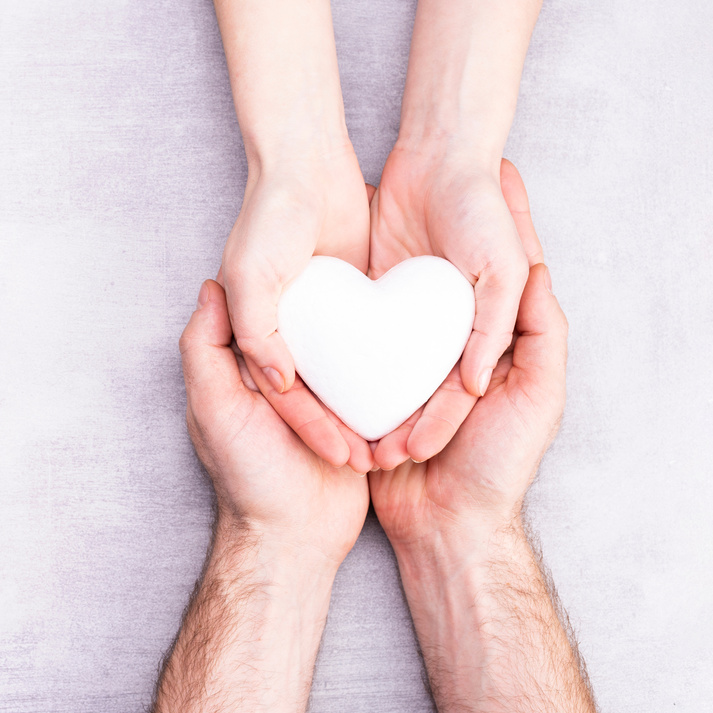 Male and Female Hands with a White Heart, Health Care, Love and Family Insurance Concept, World Heart Day, World Health Day, Foster Family, International Family Day